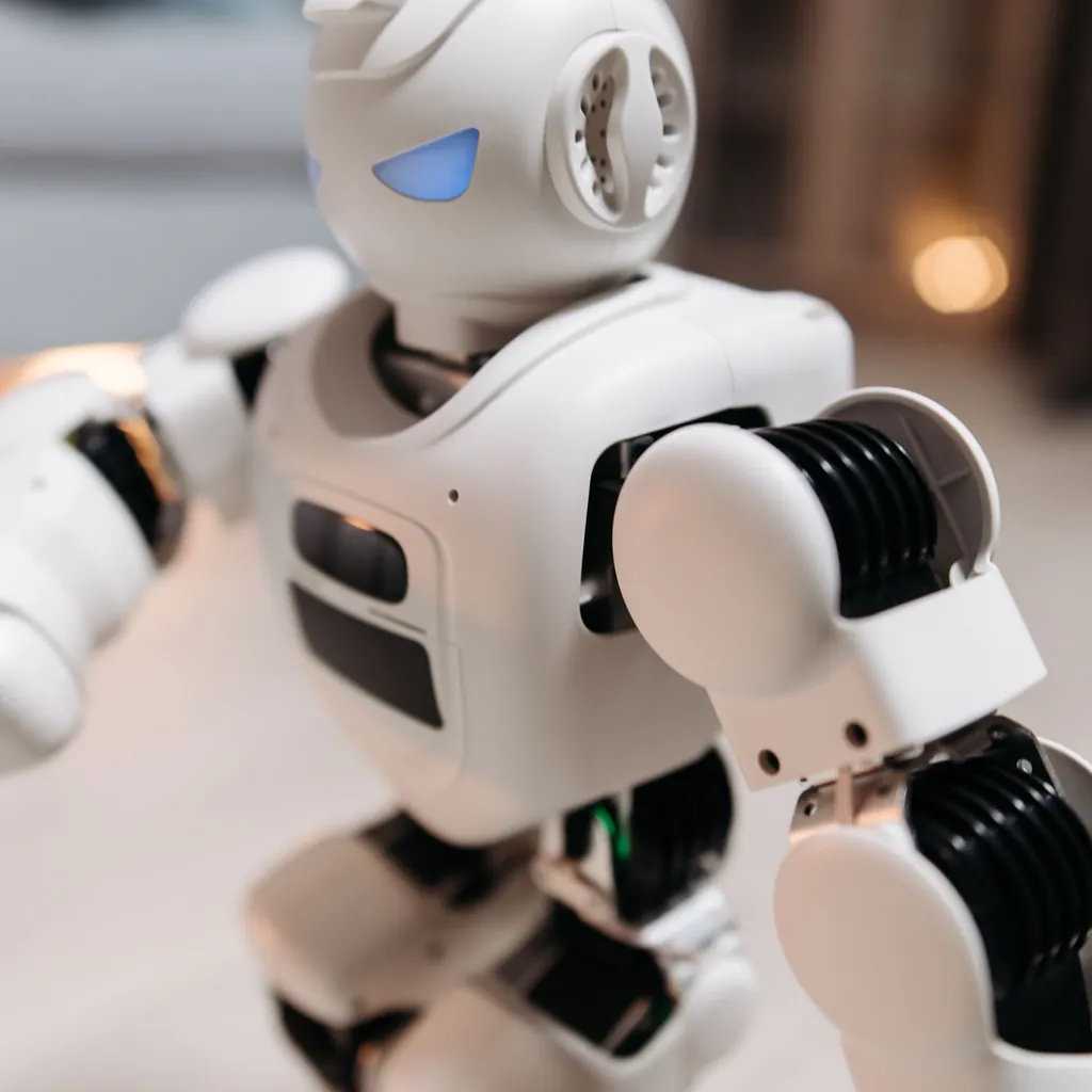 White humanoid robot reaching forward in a softly lit room