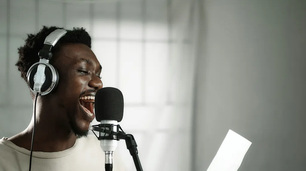 Man in headphones singing into a studio microphone, a voice you can measure in Hz