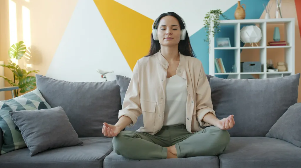 Woman doing a breathing and humming warm-up in her living room