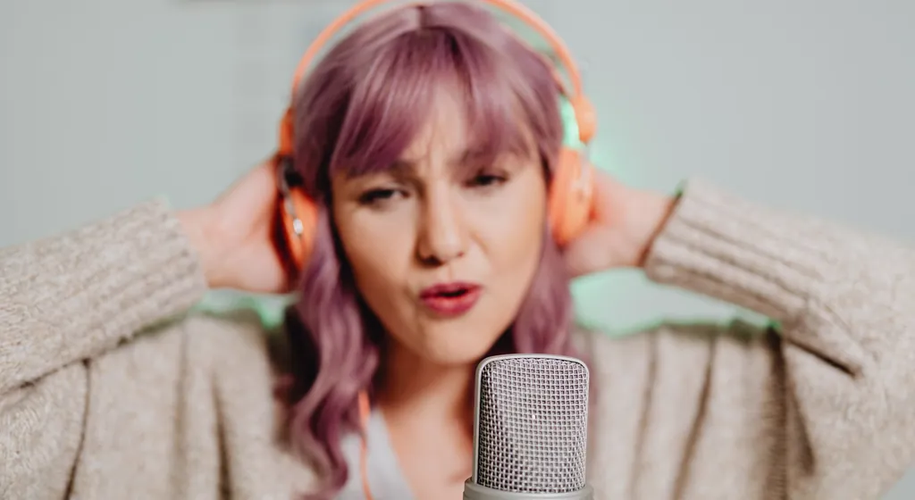 Singer with headphones practicing scales at a microphone