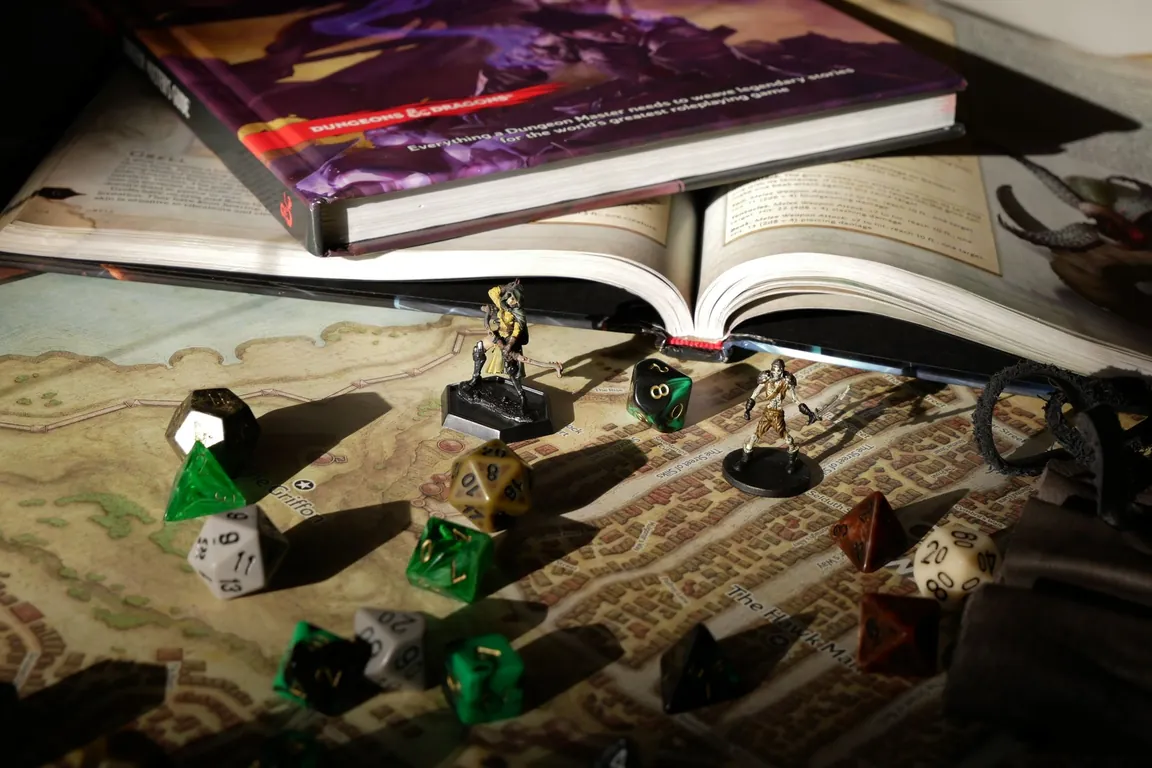 Tabletop role-playing game set up with a rule book, painted miniatures and dice