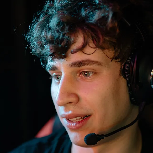 Young gamer with curly hair talking into his headset microphone