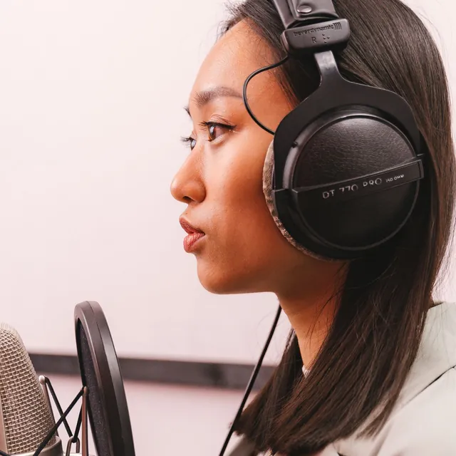Woman in headphones at a studio microphone