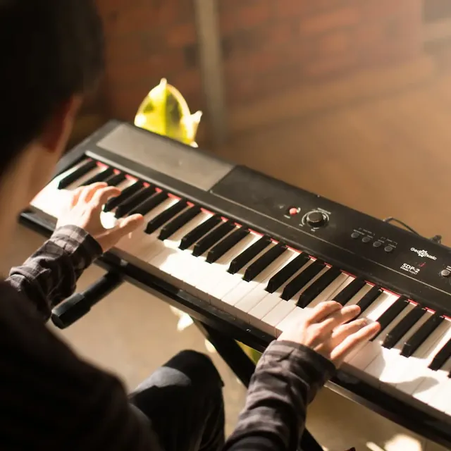 Hands playing a scale on a digital piano