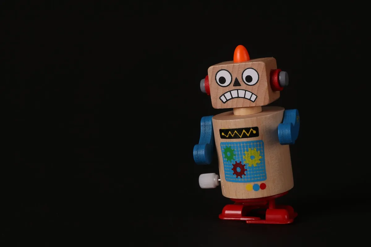Retro tin toy robot with a colorful chest panel on a black background