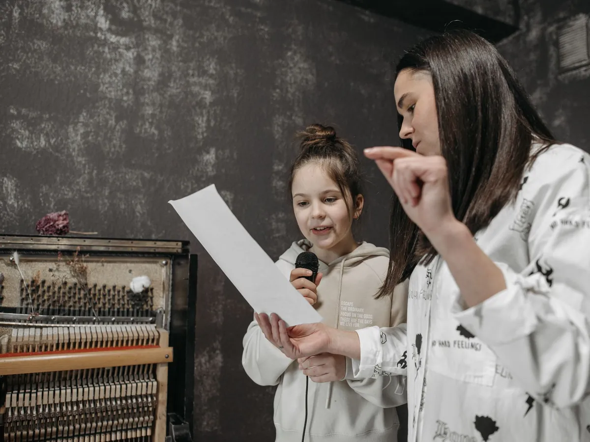 Voice teacher showing a girl how to sing a phrase from her sheet music