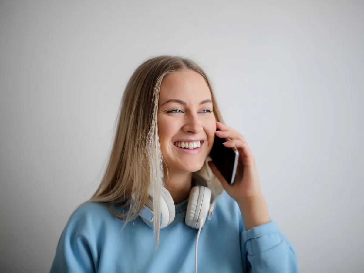 Smiling woman with a warm expression talking on her phone