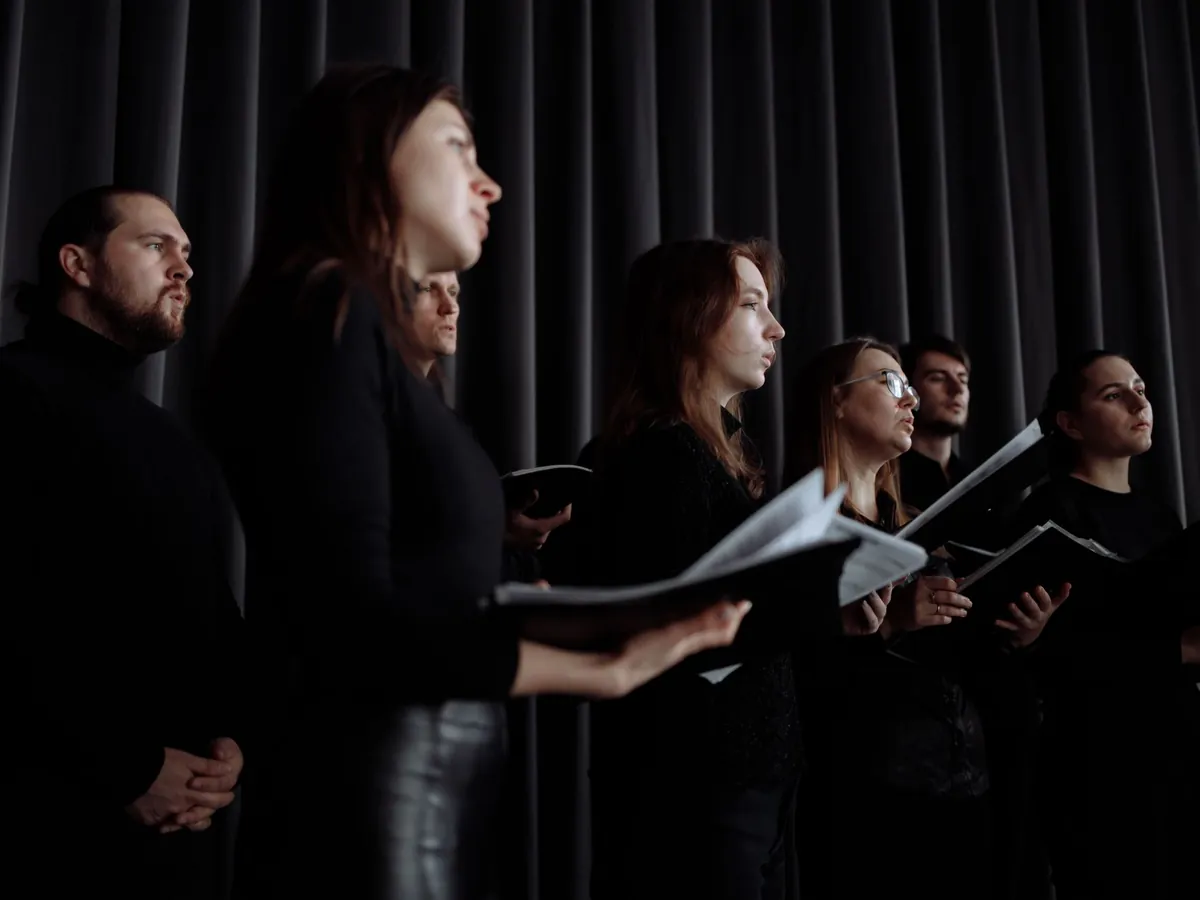 Mixed choir of men and women singing from their scores