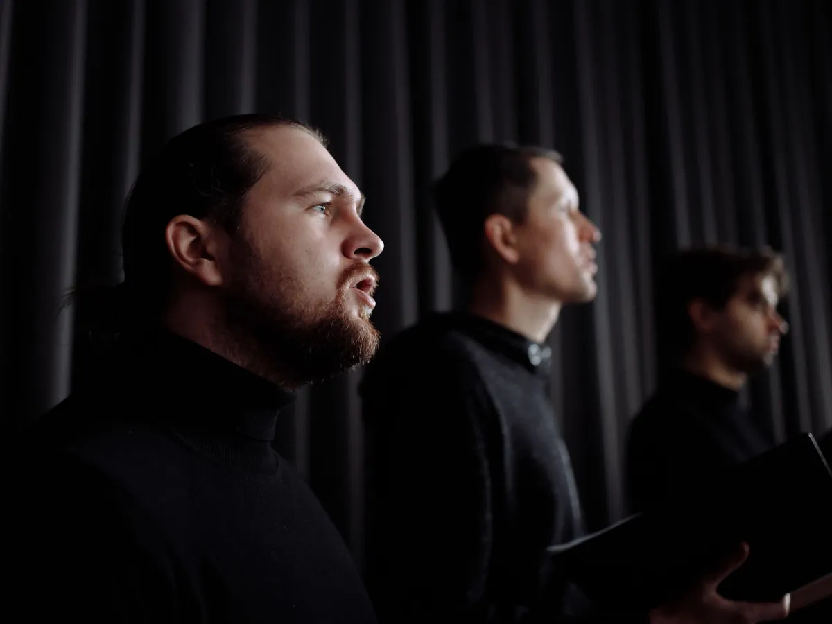 Men in a choir singing together, each holding his own line