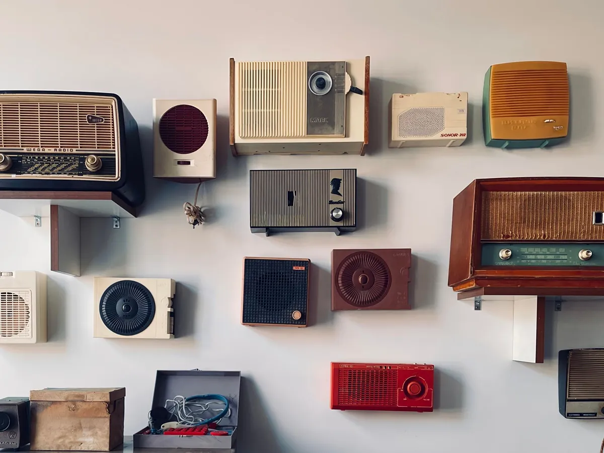 Wall display of vintage radios and speakers in pastel colors