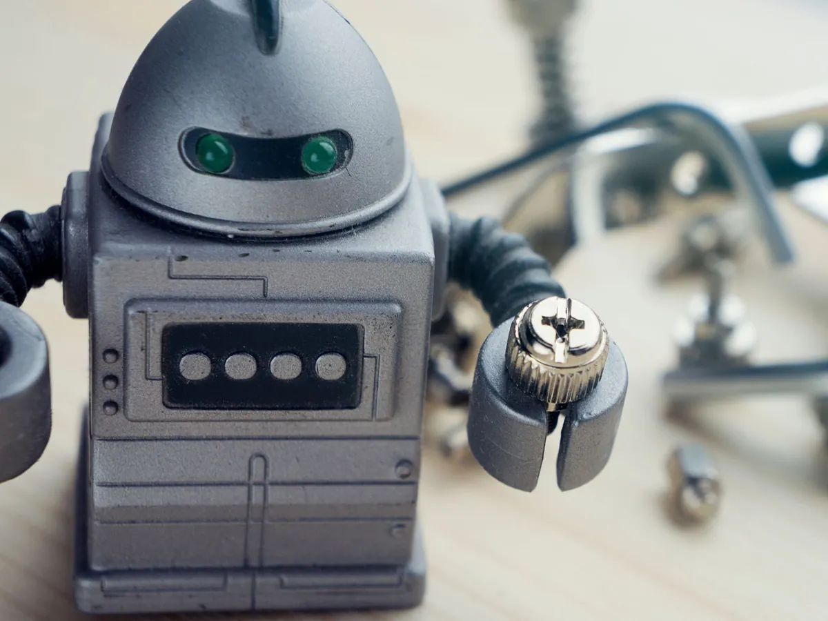 Close-up of a gray toy robot with glowing green eyes