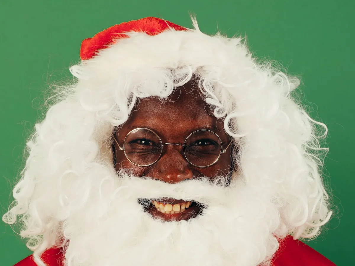 Smiling Santa Claus with a big fluffy white beard against a green background